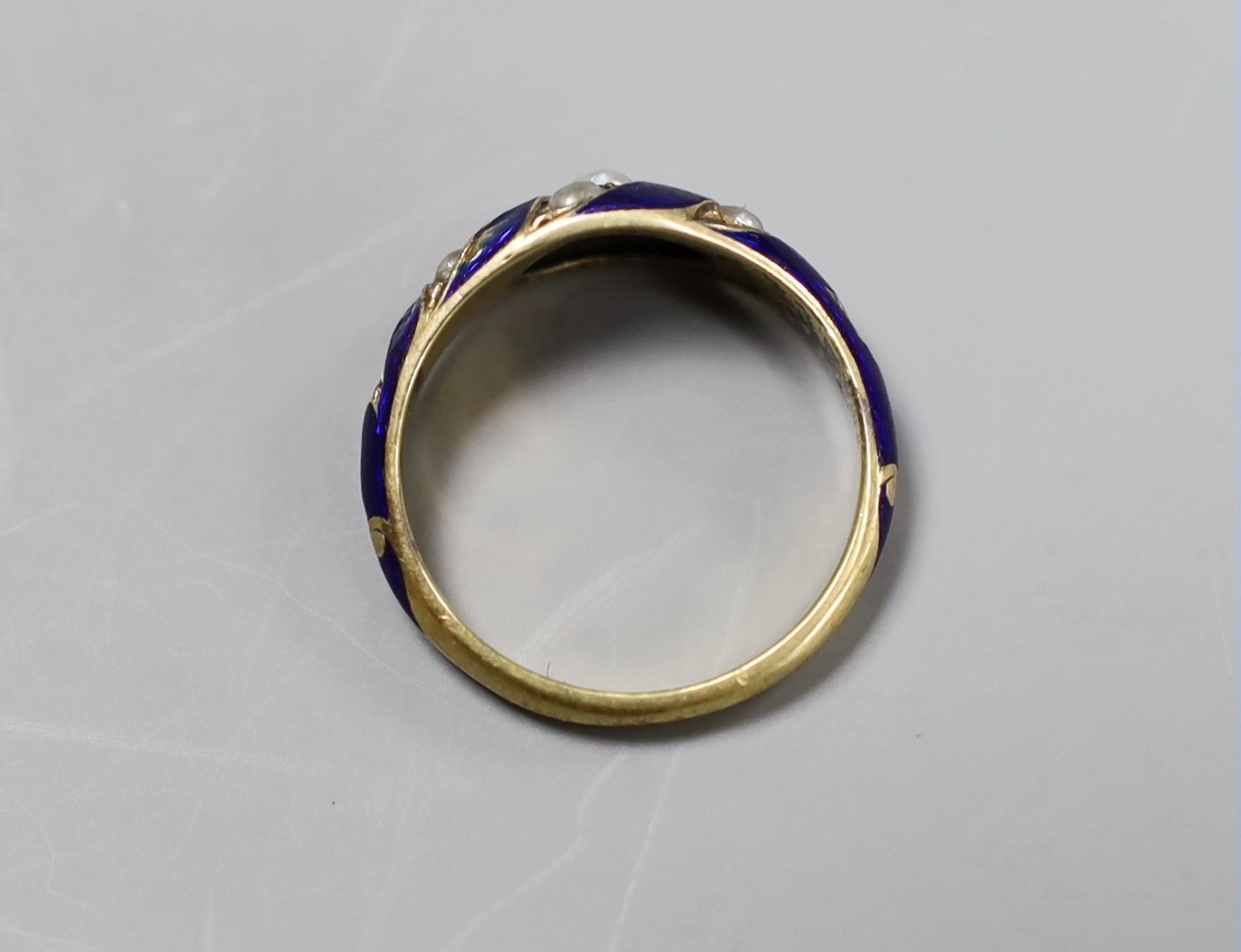 A Georgian yellow metal seed pearl and enamel ring, size M